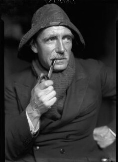 A black and white photo of Charles Pears in 1926, smoking a pipe.