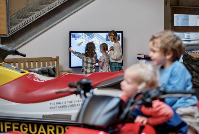 The RNLI Rescue Zone at National Maritime Museum Cornwall. Two children play on a quad bike while three other children use an interactive screen.