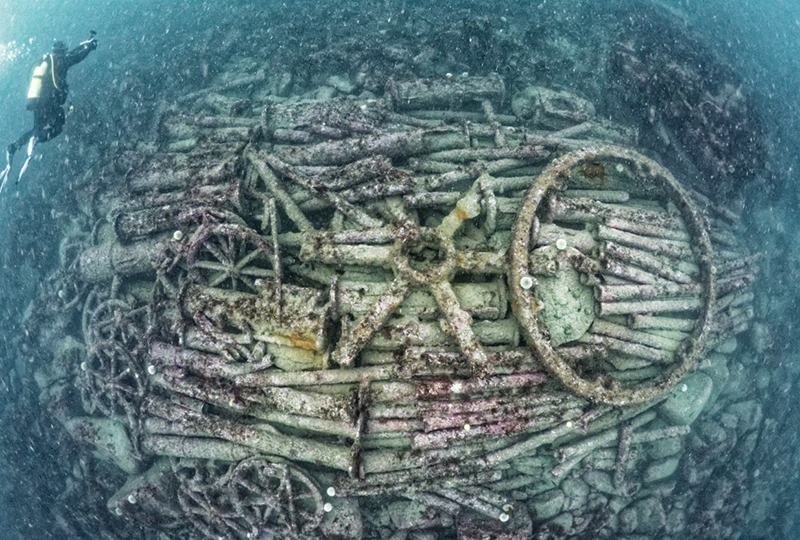 A photo of a diver visiting a shipwreck underwater.