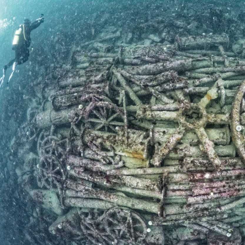 A photo of a diver visiting a shipwreck underwater.