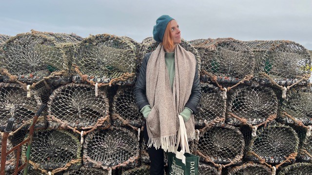 Clare Howdle standing in front of a pile of lobster pots.