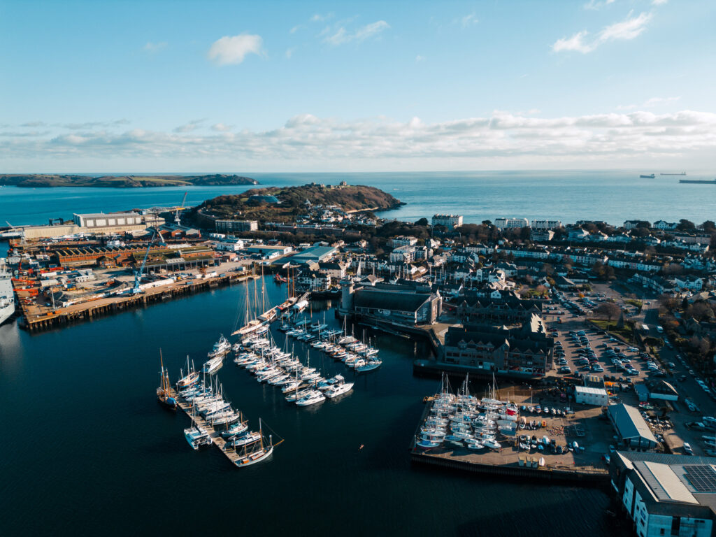 An aerial shot of NMMC and Falmouth Harbour on a blue-sky day.