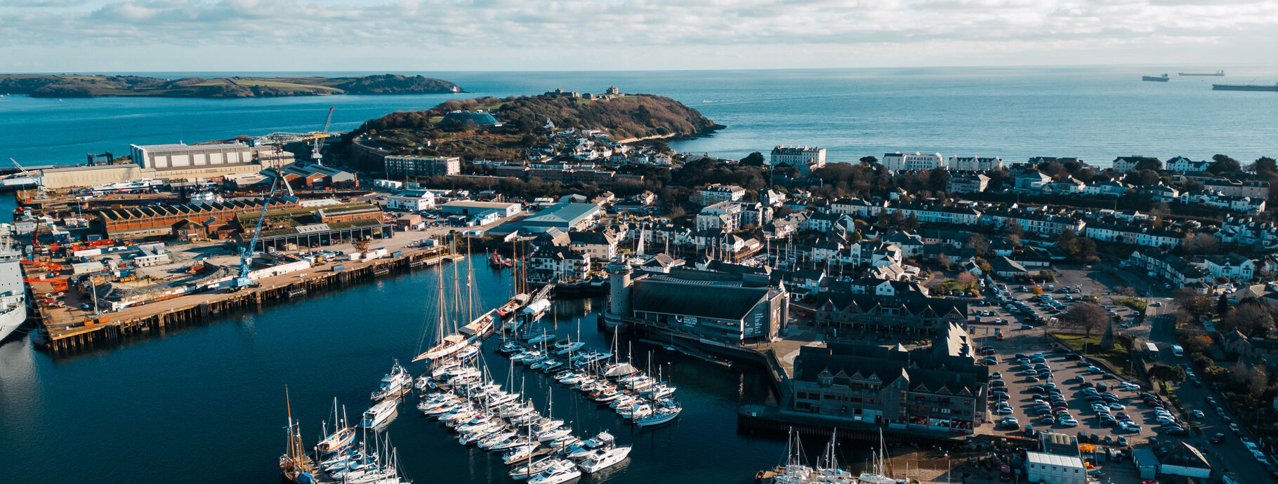 An aerial shot of NMMC and Falmouth Harbour on a blue-sky day.