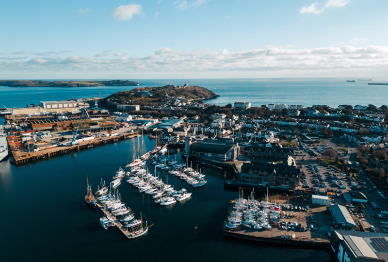 An aerial shot of NMMC and Falmouth Harbour on a blue-sky day.