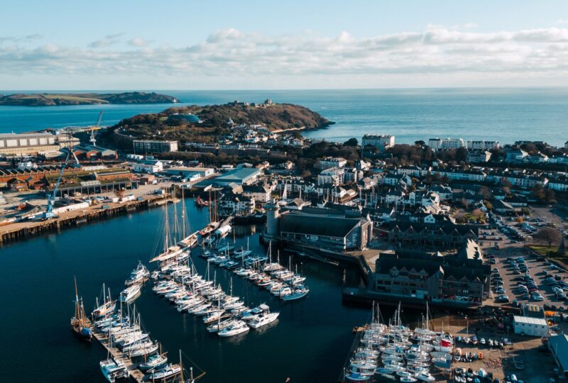 An aerial shot of NMMC and Falmouth Harbour on a blue-sky day.