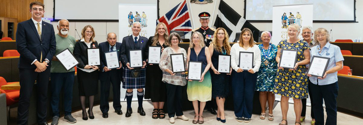 A group photo of all of nominees for the Kings Award for Voluntary Service holding their certificate.