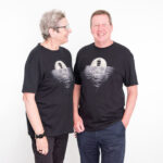 A man and a women wearing the Pirates Exhibition T-Shirt