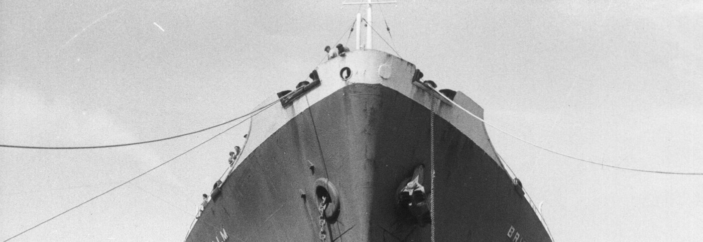 A black and white photograph of a large ship in a dock