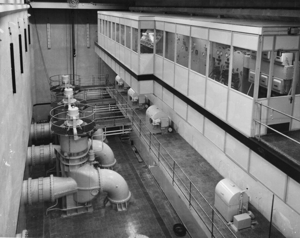 A black and white photograph of the dock pump room, showing pumps and viewing platform.