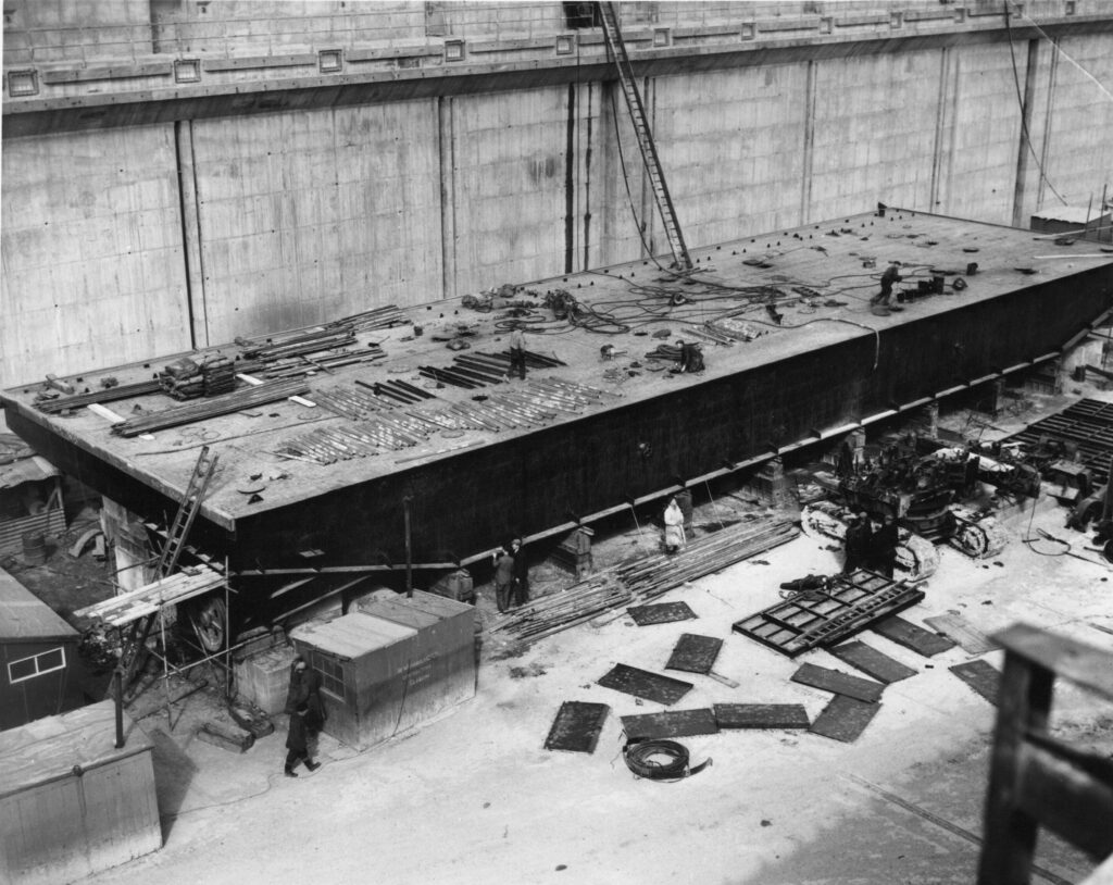 A black and white photograph showing work on assembling the box-type one piece Dock Gate.