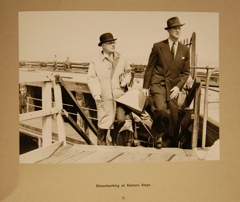 A Black and White Photograph showing two smartly dressed people disembarking the docks.