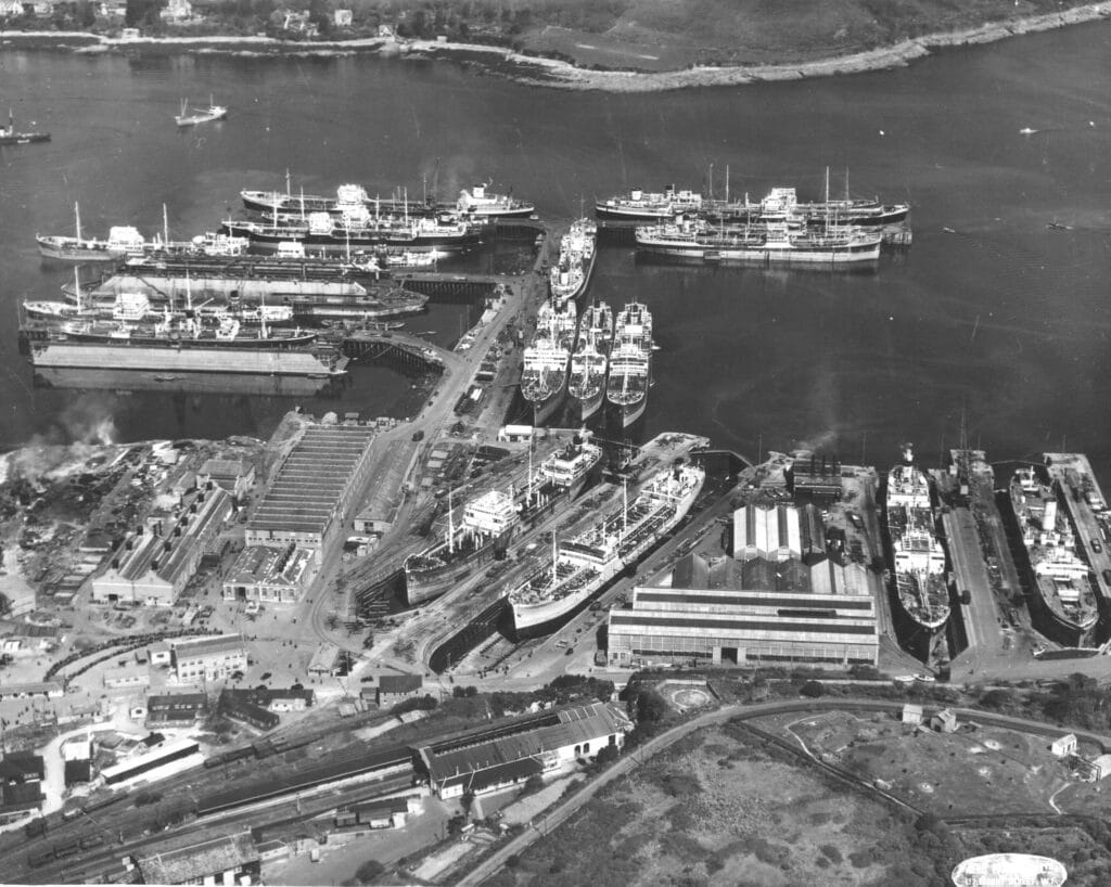 A Black & White photograph taken from a height showing Falmouth docks with many ships, in the post-war period.