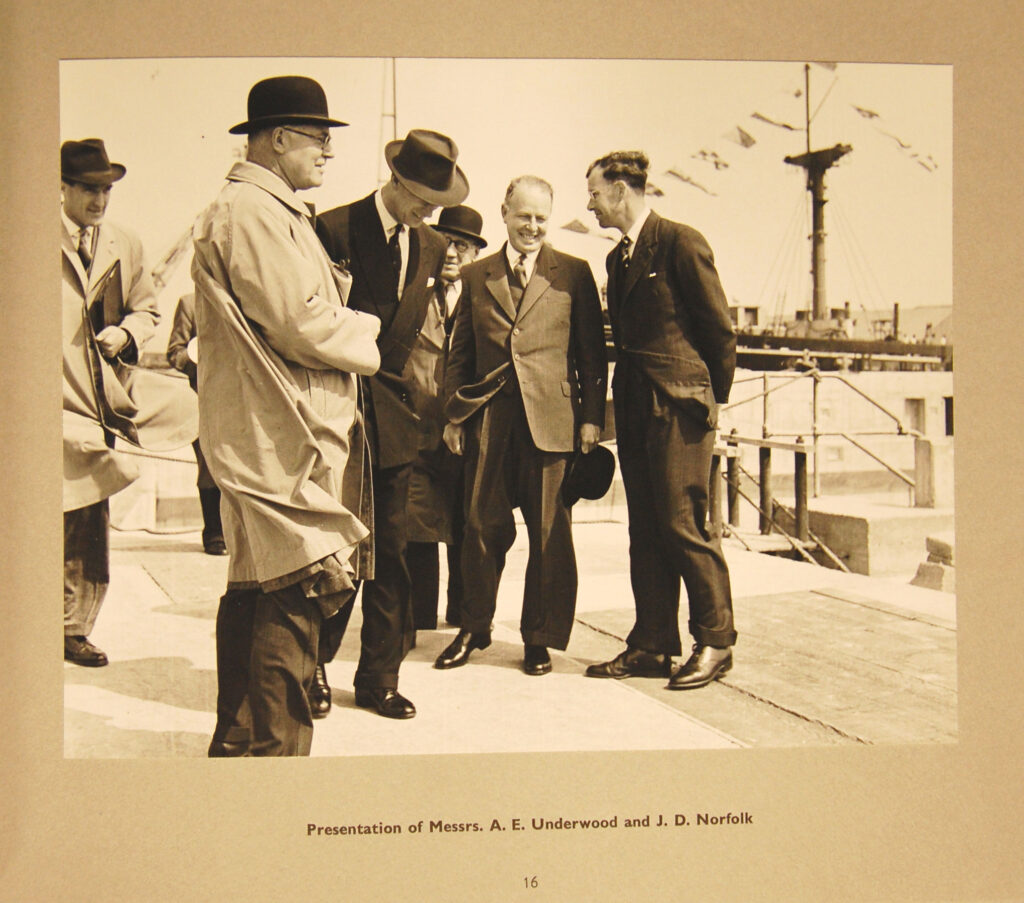 A Black and White Photograph showing a group of people being introduced to the Duke of Edinburgh.