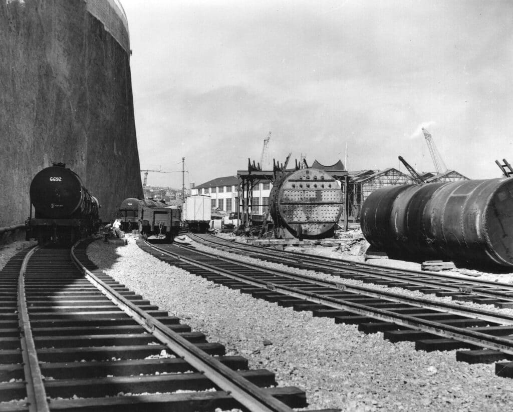 A black and white photograph showing roads and railways leading to the docks.