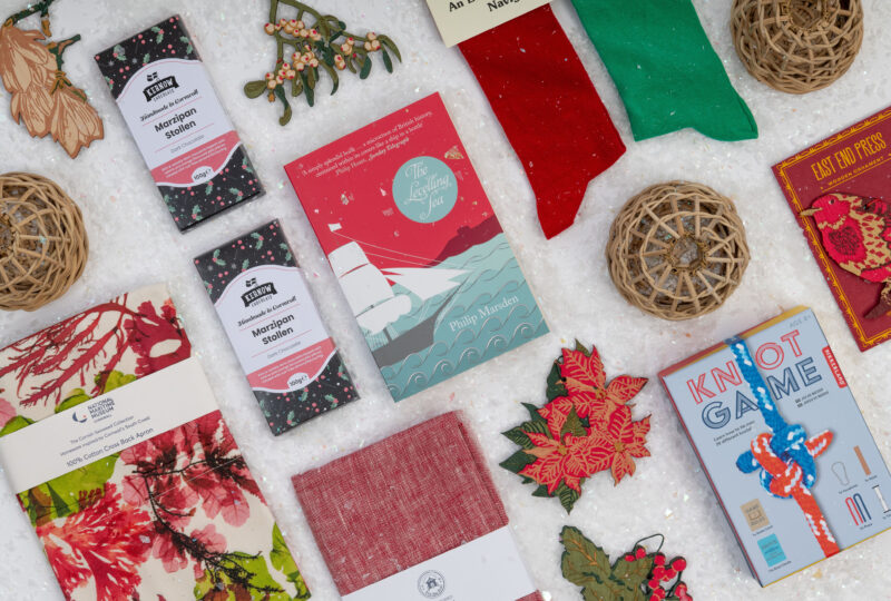 A photograph taken from above showing a collection of products arranged on a flat table covered in artificial snow.