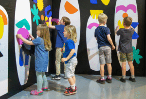 Children enjoying playing with colourful surfboard magnets in the SURF! exhibition at National Maritime Museum Cornwall.