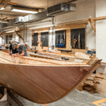 Members of the boatbuilding team working on the Helford SOE boat replica build in the boatbuilding workshop at National Maritime Museum Cornwall.