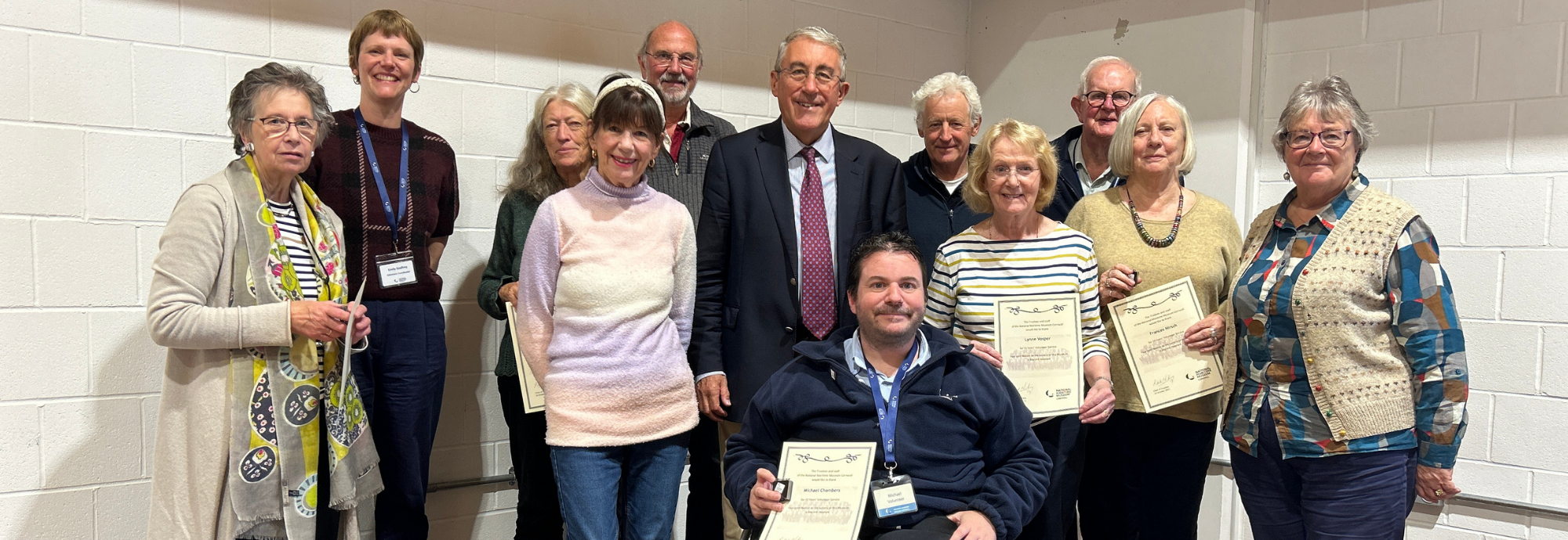 A group of Museum volunteers holding their Long Service Award certificates.