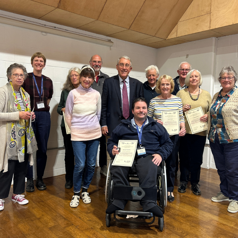 A group of Museum volunteers holding their Long Service Award certificates.