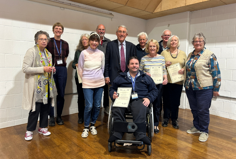 A group of Museum volunteers holding their Long Service Award certificates.
