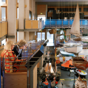 Two visitors examine an interactive screen in the Boat Hall of the National Maritime Museum Cornwall.
