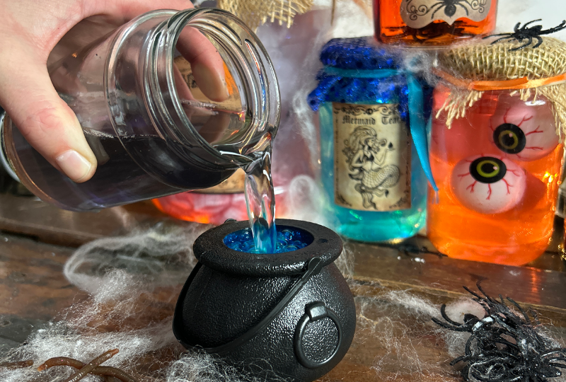 Halloween potion making in a witch's apothecary with a small cauldron