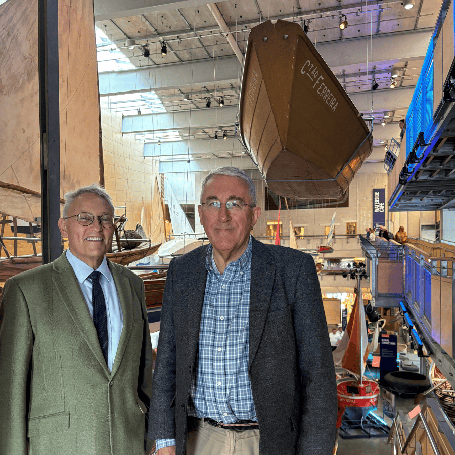 Two men, NMMC Director Richard Doughty and NMMC Board Chair Dr Patrick Newberry, stand side-by-side in the Boat Hall of National Maritime Museum Cornwall.