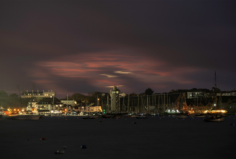 The Lookout Tower and Museum building in Falmouth Harbour under a cloudy pink twilight sky.